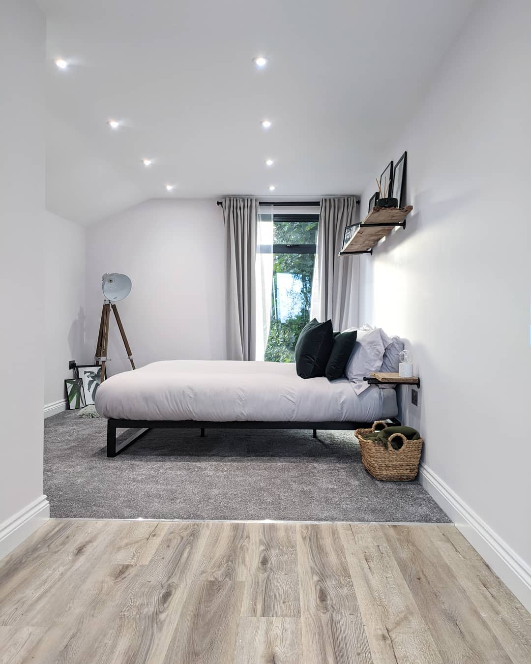 small bedroom garage wood wall shelf wicker clothes basket gray carpet floor 